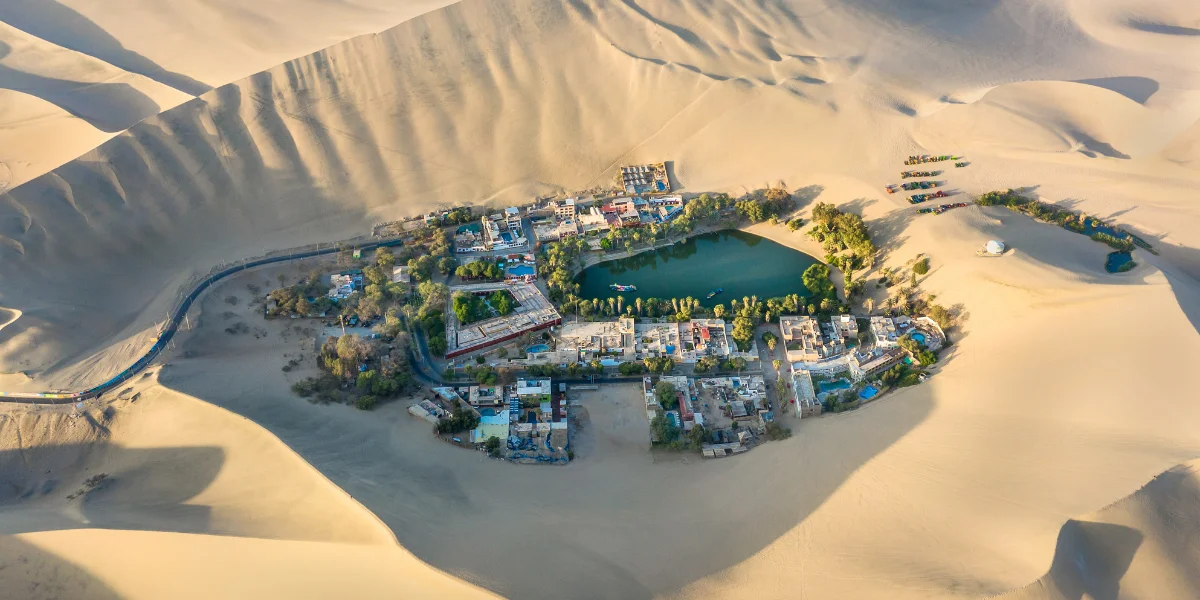 Aerial view of Huacachina Oasis with lagoon and sand dunes in Peruvian desert - Peru Bucket List
