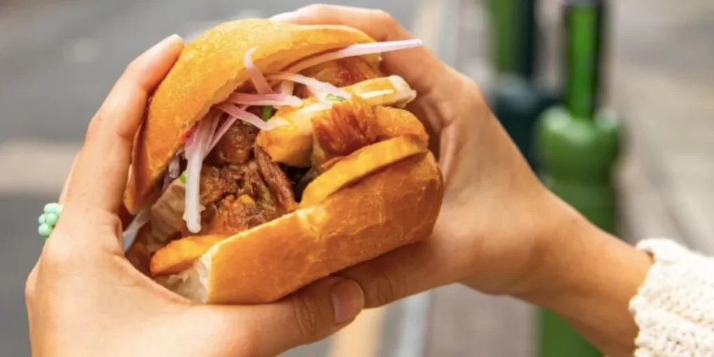 Pan Con Chicharron Peruvian breakfast dish with salsa criolla