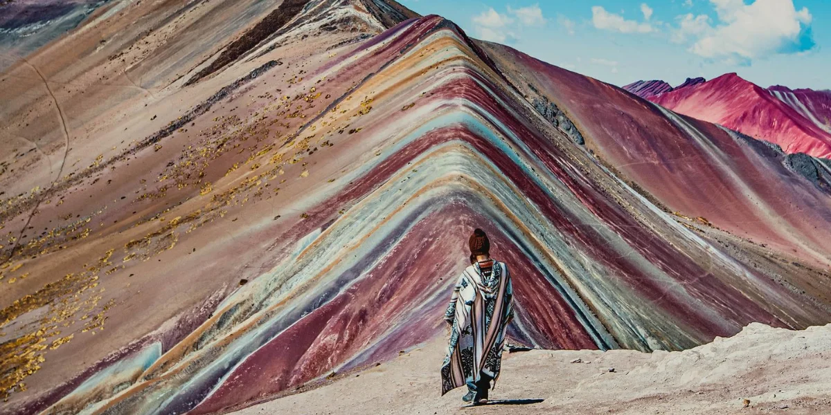 Essential packing list for hiking Rainbow Mountain Peru, including boots, layers, water, and rain gear for changing weather