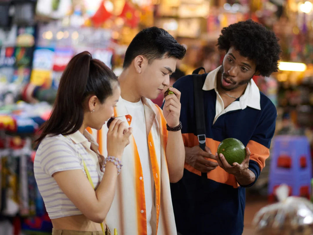 Travelers tasting fresh local fruits while exploring the famous Central Market of Lima during an authentic food tour.