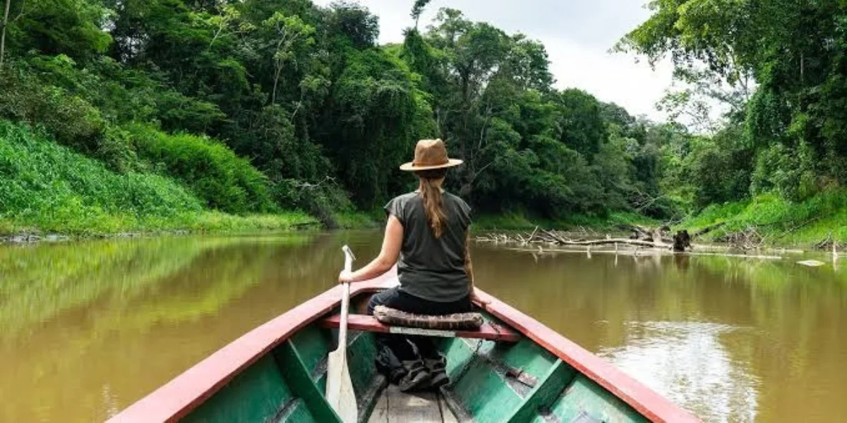 Traveler exploring the Amazon rainforest by canoe near Iquitos Peru